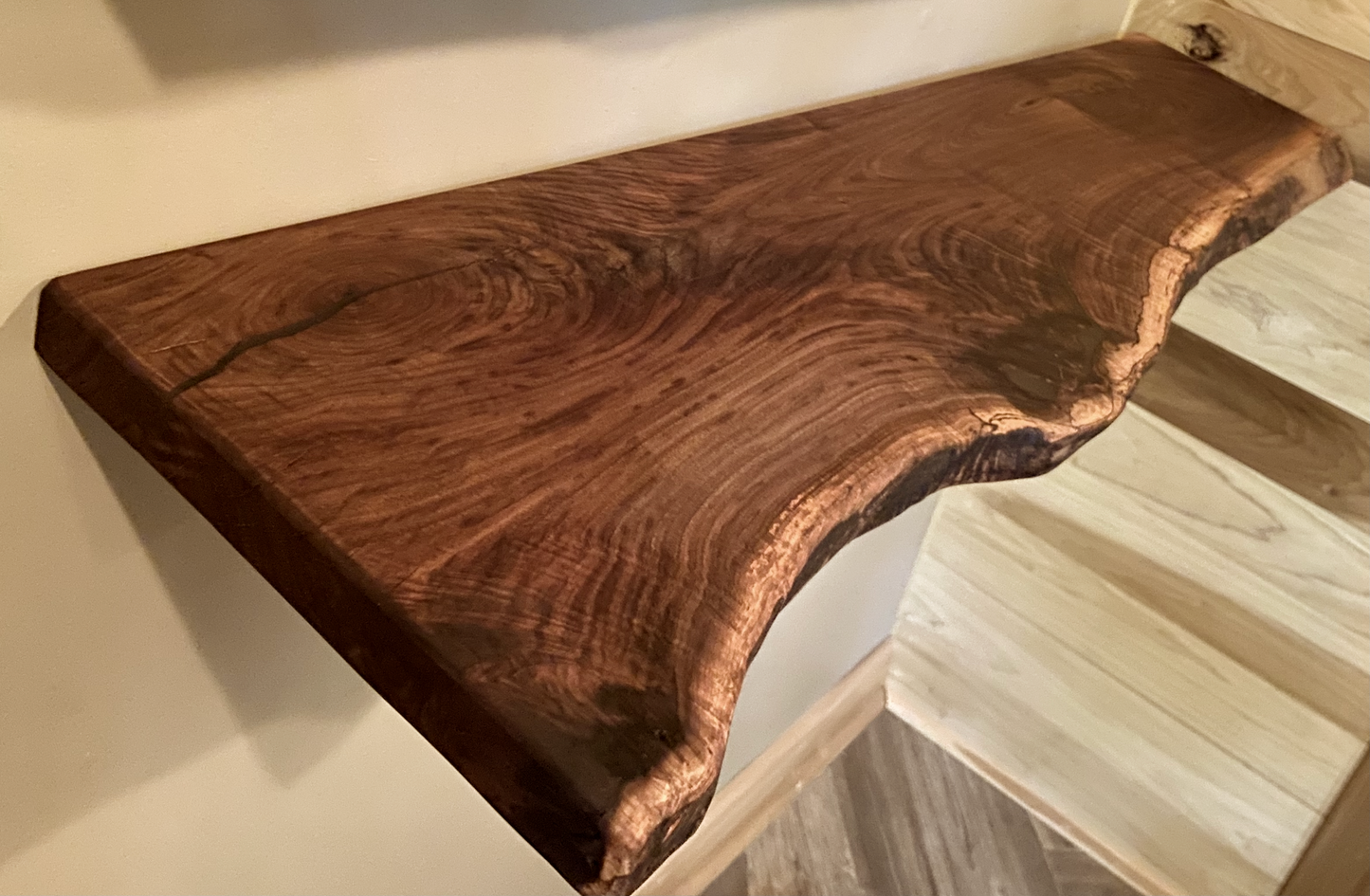 Custom live edge walnut shelves featuring rich, dark brown wood grain and organic edges. Handcrafted for stylish, rustic home decor.