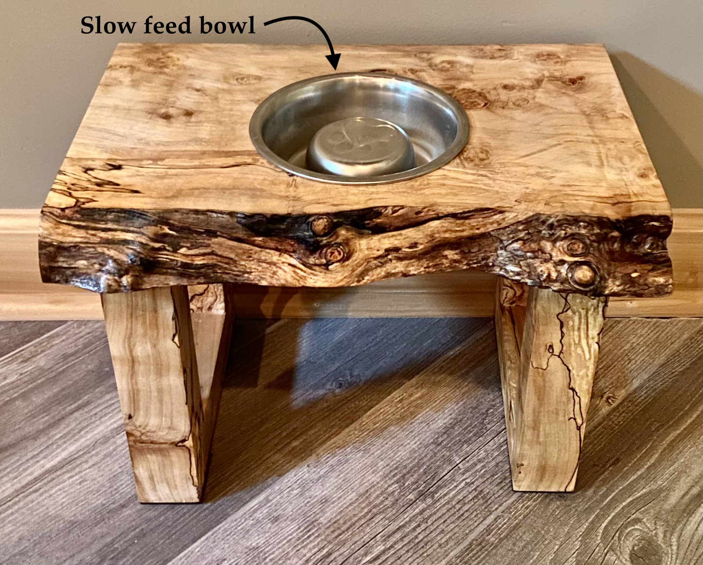 Live edge raised pet stand crafted from spalted maple or black walnut, featuring one stainless steel bowls for food and water. Elevated pet feeder, showcasing the natural wood grain and sturdy construction. Top-down view highlighting the placement of the three stainless steel bowls within the live edge wooden stand. Detailed close-up of the spalted maple’s unique wood grain patterns on the pet stand.