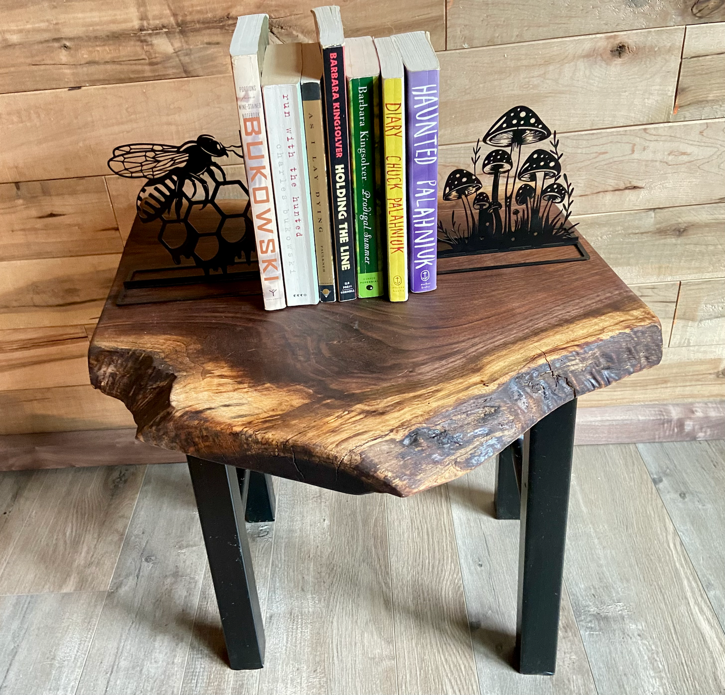 Top-down view of a live edge walnut side table with rich natural grain and smooth finish, set against a maple wall. Live edge walnut side table styled with everyday items, showing rustic charm and organic wood edge.