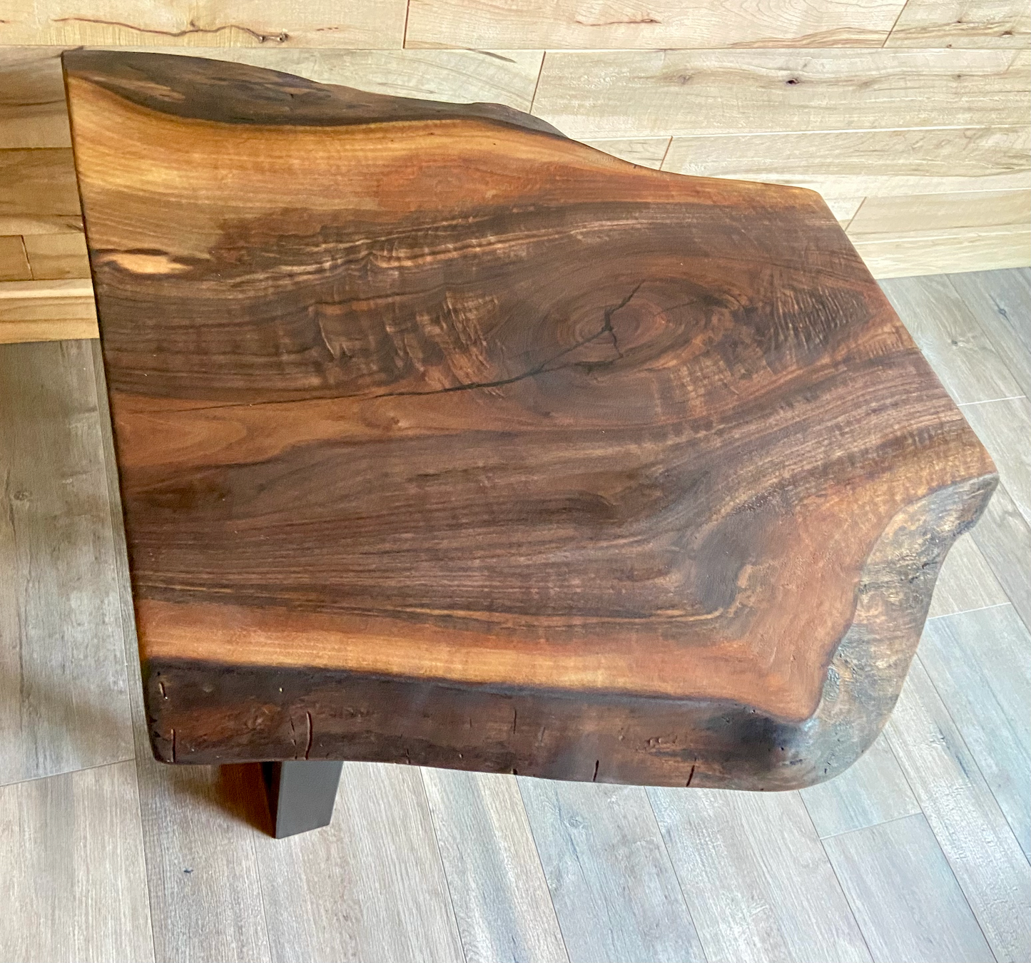 Wooden accent table with a natural grain pattern on a wooden floor.