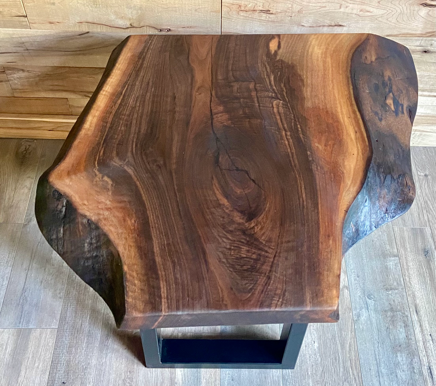 Wooden side table with a natural grain pattern on a wooden floor.
