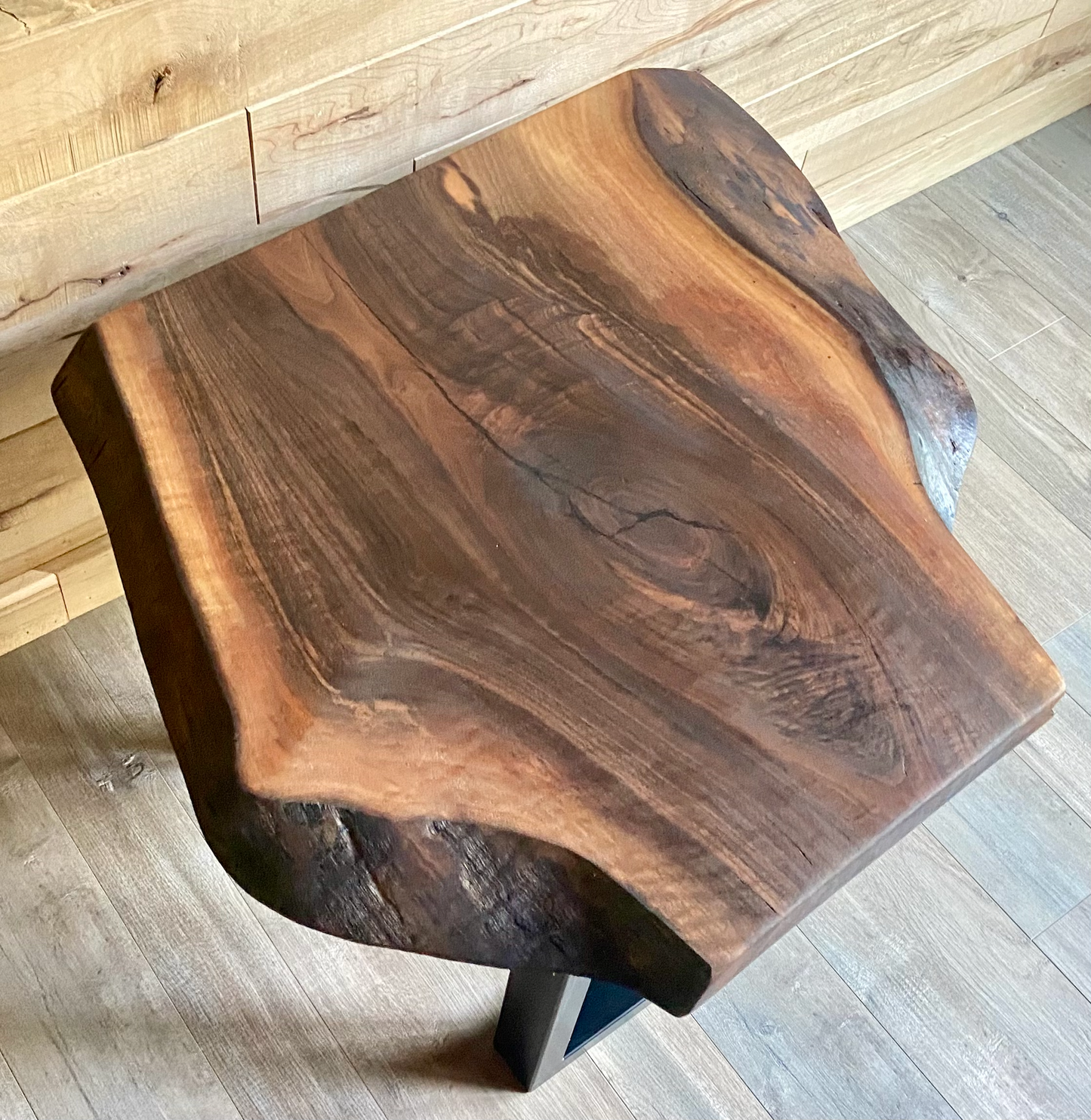 Wooden small coffee table with a natural finish on a wooden floor.