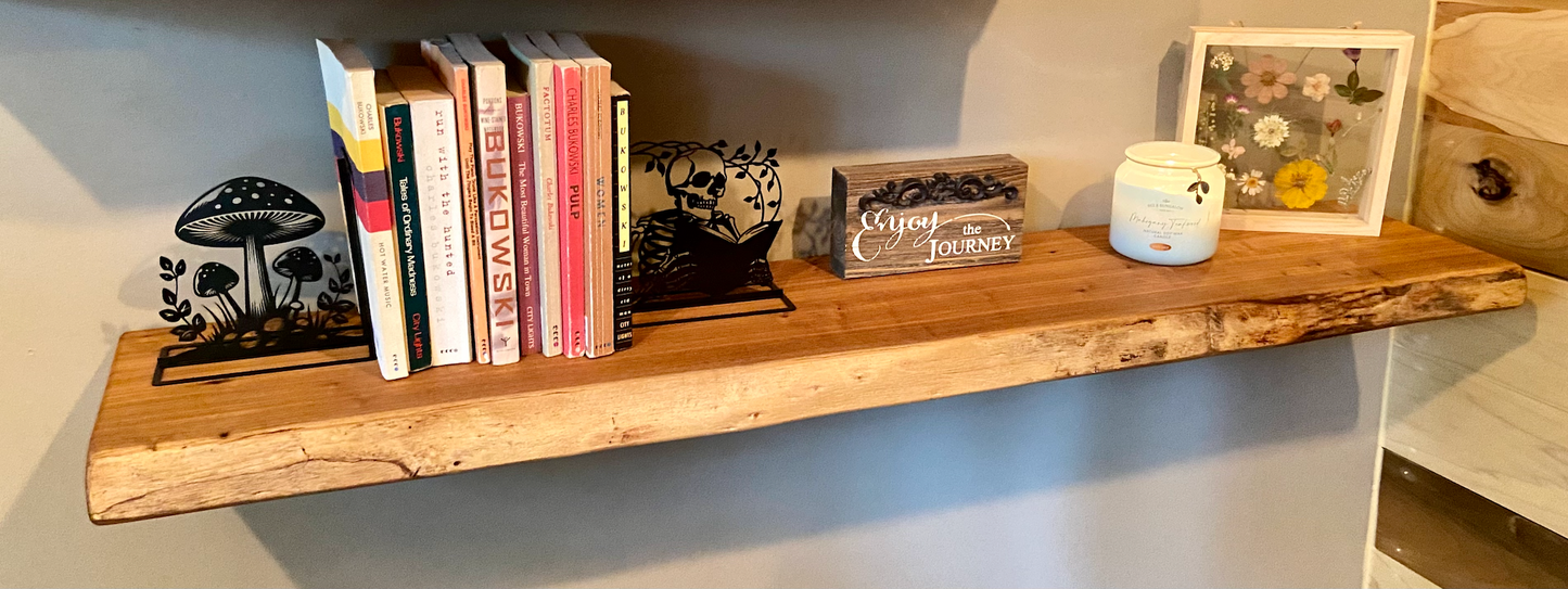 Close-up side view of a rustic live edge wood floating shelf showing natural grain and curvature.