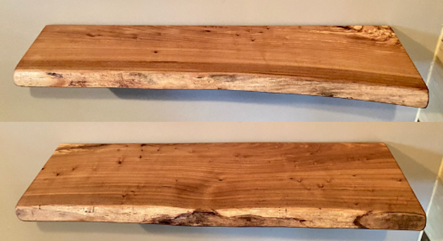 A set of two handcrafted live edge floating shelves made from solid hardwood, mounted on a neutral wall.