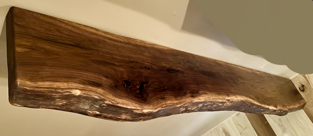 Custom live edge walnut shelves featuring rich, dark brown wood grain and organic edges. Handcrafted for stylish, rustic home decor.