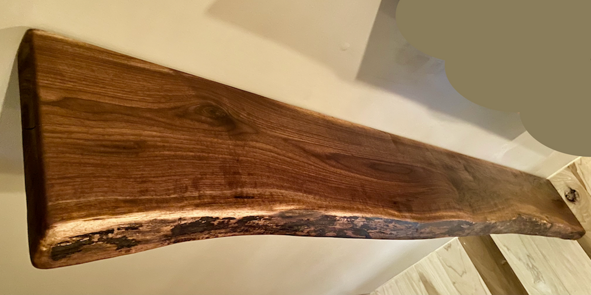 Custom live edge walnut shelves featuring rich, dark brown wood grain and organic edges. Handcrafted for stylish, rustic home decor.