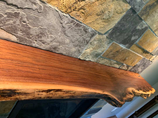 Custom live edge walnut shelves featuring rich, dark brown wood grain and organic edges. Handcrafted for stylish, rustic home decor.