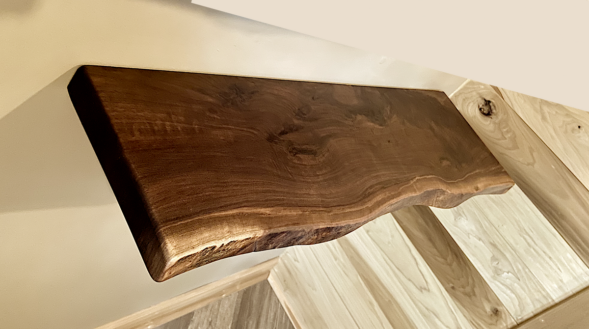 Custom live edge walnut shelves featuring rich, dark brown wood grain and organic edges. Handcrafted for stylish, rustic home decor.