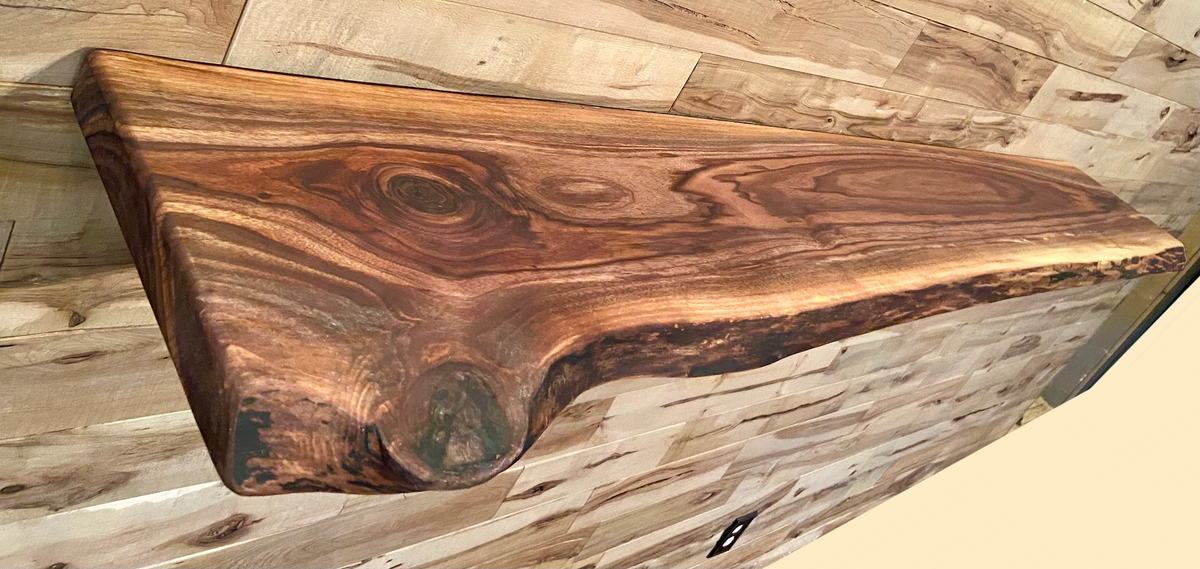 Custom live edge walnut shelves featuring rich, dark brown wood grain and organic edges. Handcrafted for stylish, rustic home decor.