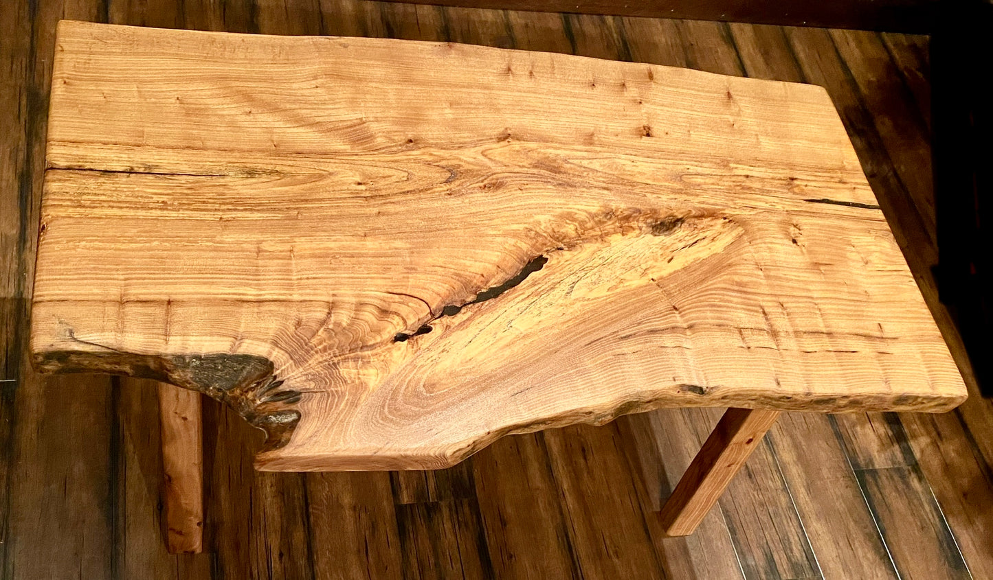 Live edge chestnut wood with a natural, rustic finish on a wooden floor.