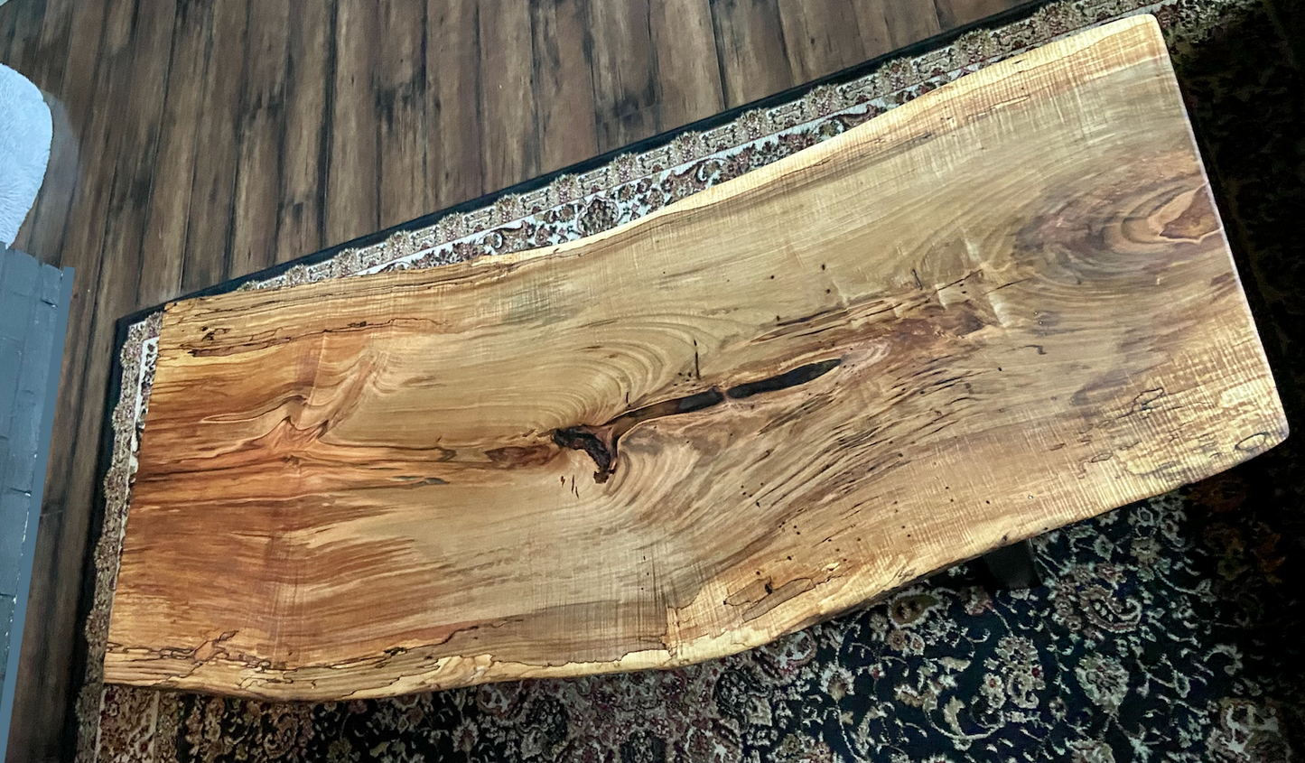 Top-down view of live edge ambrosia maple coffee table, highlighting natural wood grain, warm tones, and live edge details. Handcrafted ambrosia maple coffee table styled in a modern living room with a cozy, rustic aesthetic. Detailed view of ambrosia maple wood grain, showing natural spalting, color variations, and organic patterns. Curved live edge coffee table made from ambrosia maple, featuring unique grain patterns and a smooth, polished surface. Rustic and modern design.