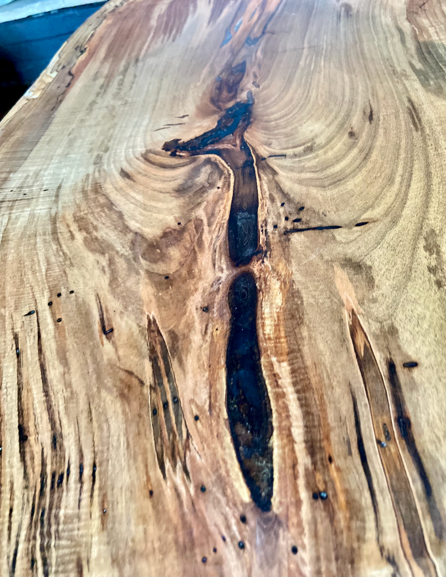 Top-down view of live edge ambrosia maple coffee table, highlighting natural wood grain, warm tones, and live edge details. Detailed view of ambrosia maple wood grain, showing natural spalting, color variations, and organic patterns. Curved live edge coffee table made from ambrosia maple, featuring unique grain patterns and a smooth, polished surface. Rustic and modern design.
