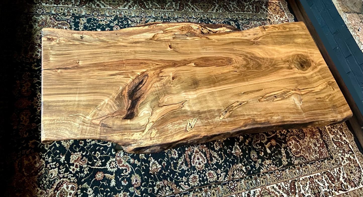 Top-down view of live edge ambrosia maple coffee table, highlighting natural wood grain, warm tones, and live edge details. Handcrafted ambrosia maple coffee table styled in a modern living room with a cozy, rustic aesthetic. Detailed view of ambrosia maple wood grain, showing natural spalting, color variations, and organic patterns. Curved live edge coffee table made from ambrosia maple, featuring unique grain patterns and a smooth, polished surface. Rustic and modern design.