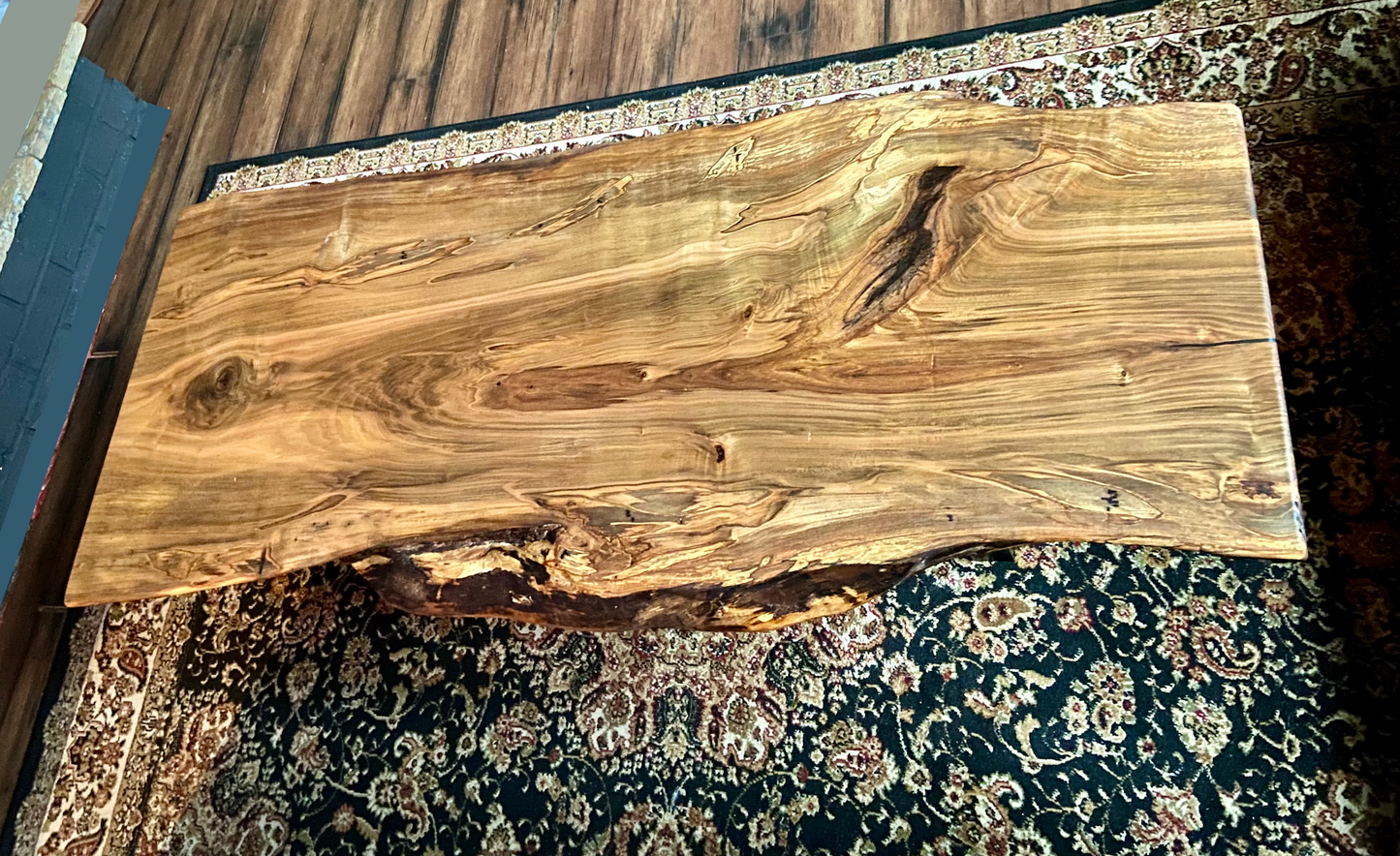 Top-down view of live edge ambrosia maple coffee table, highlighting natural wood grain, warm tones, and live edge details. Handcrafted ambrosia maple coffee table styled in a modern living room with a cozy, rustic aesthetic. Detailed view of ambrosia maple wood grain, showing natural spalting, color variations, and organic patterns. Curved live edge coffee table made from ambrosia maple, featuring unique grain patterns and a smooth, polished surface. Rustic and modern design.