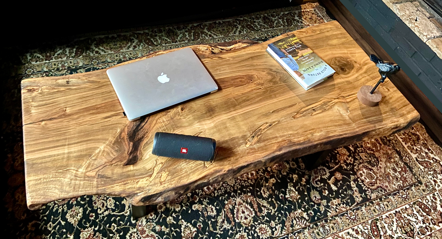 Top-down view of live edge ambrosia maple coffee table with household items, highlighting natural wood grain, and live edge details. Handcrafted ambrosia maple coffee table styled in a modern living room with a cozy, rustic aesthetic. Detailed view of ambrosia maple wood grain, showing natural spalting, color variations, and organic patterns. Curved live edge coffee table made from ambrosia maple, featuring unique grain patterns and a smooth, polished surface. Rustic and modern design.