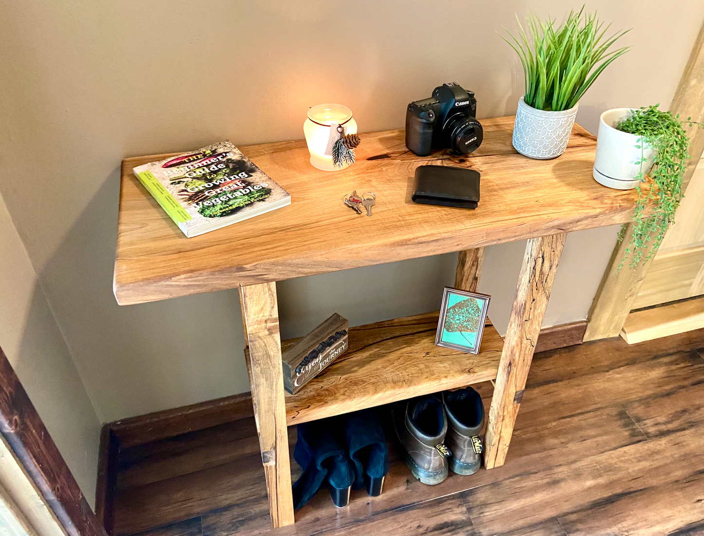 Top-down view of spalted maple sofa or console table with household items, highlighting natural wood grain, warm tones, and wood details. Handcrafted spalted maple console / sofa table styled in a modern living room with a cozy, rustic aesthetic. Detailed view of spalted maple wood grain, showing natural spalting, color variations, and organic patterns. Straight edge entryway table made from spalted maple, featuring unique grain patterns and a smooth, polished surface. Rustic and modern design.