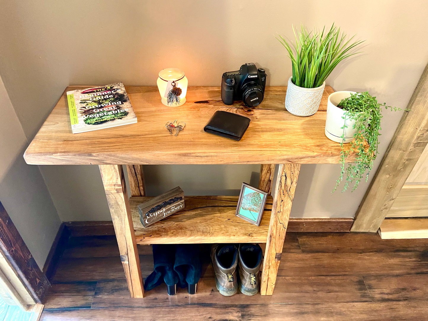 Top-down view of spalted maple sofa or console table with household items, highlighting natural wood grain, warm tones, and wood details. Handcrafted spalted maple console / sofa table styled in a modern living room with a cozy, rustic aesthetic. Detailed view of spalted maple wood grain, showing natural spalting, color variations, and organic patterns. Straight edge entryway table made from spalted maple, featuring unique grain patterns and a smooth, polished surface. Rustic and modern design.