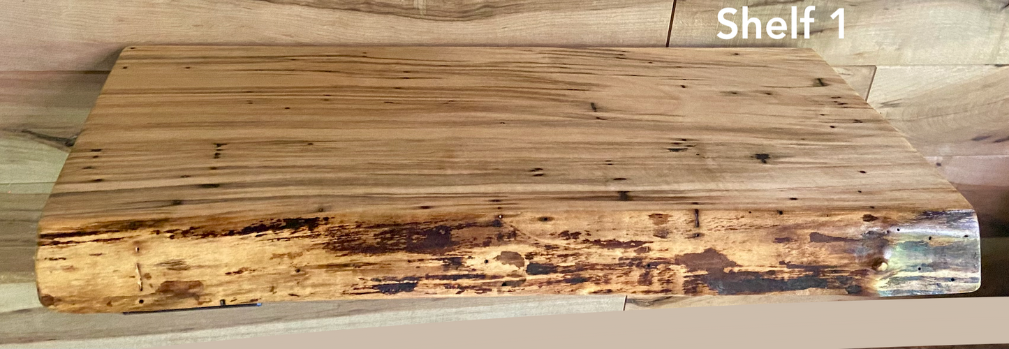 Live edge ambrosia maple floating shelf with live edge and natural grain pattern mounted on wall.