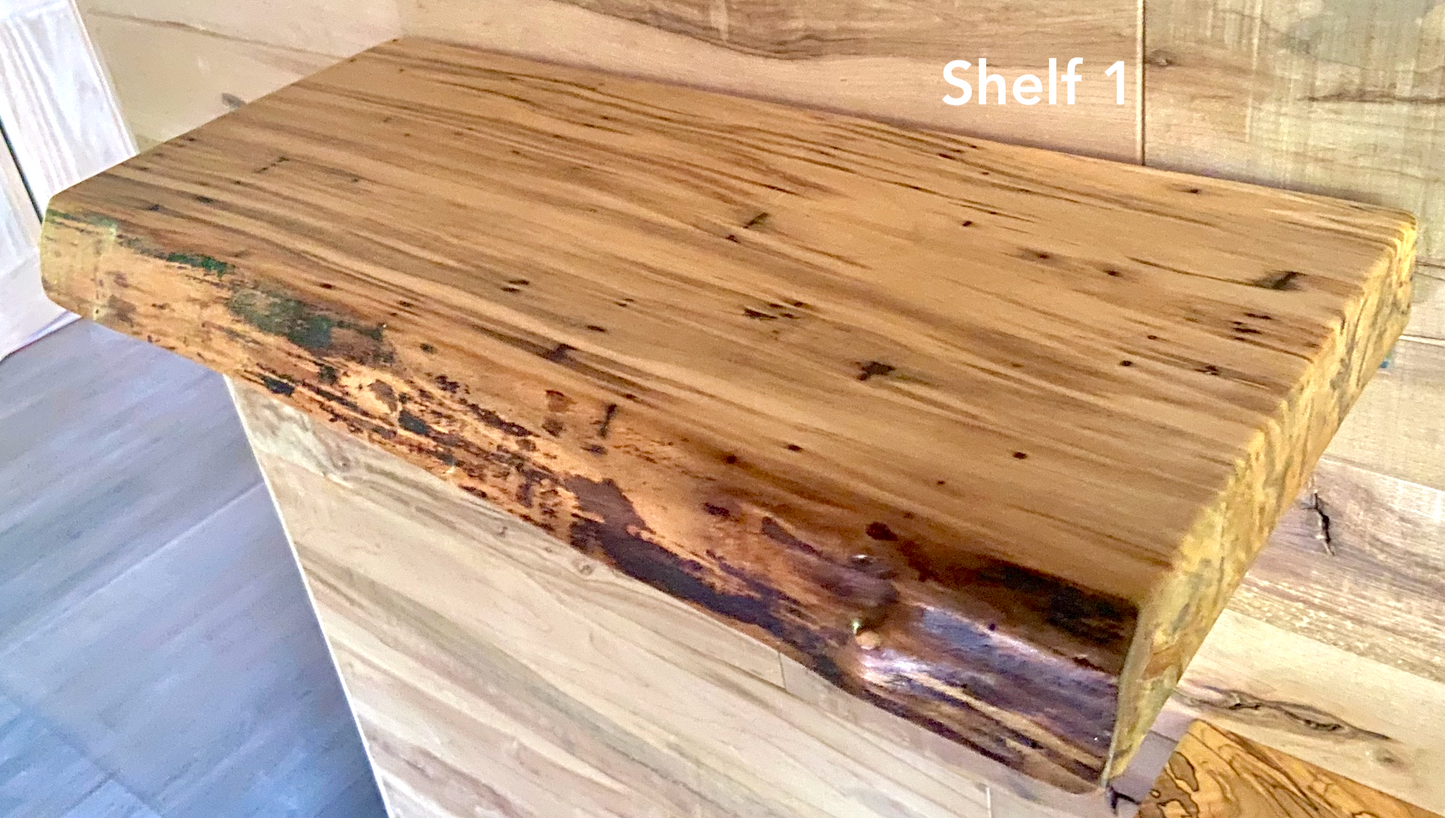 Live edge ambrosia maple floating shelf with live edge and natural grain pattern mounted on wall.