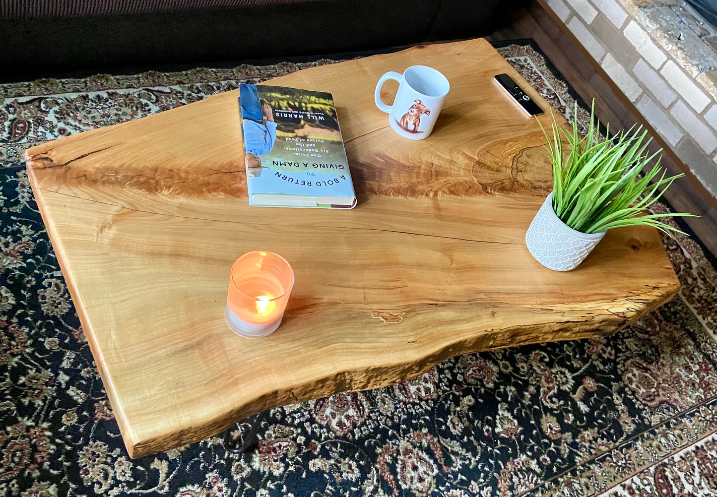 Top-down view of live edge maple coffee table with household items, highlighting natural wood grain, and live edge details. Handcrafted spalted maple coffee table styled in a modern living room with a cozy, rustic aesthetic. Detailed view of fiddleback maple wood grain, showing natural spalting, color variations, and organic patterns. Forked live edge coffee table made from spalted maple, featuring unique grain patterns and a smooth, polished surface. Rustic and modern design.