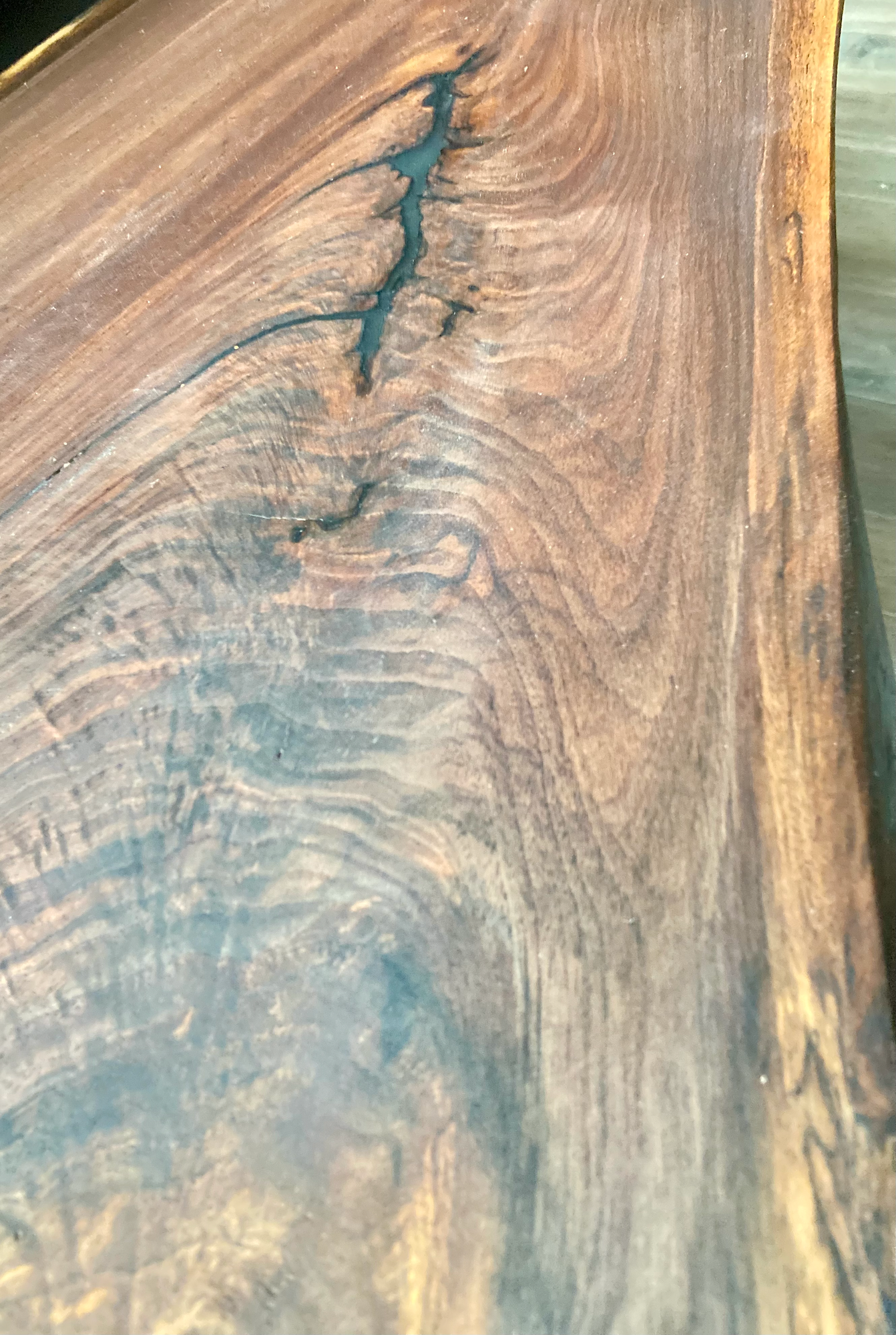 Close up of live edge walnut side table highlighting grain pattern and natural edge.