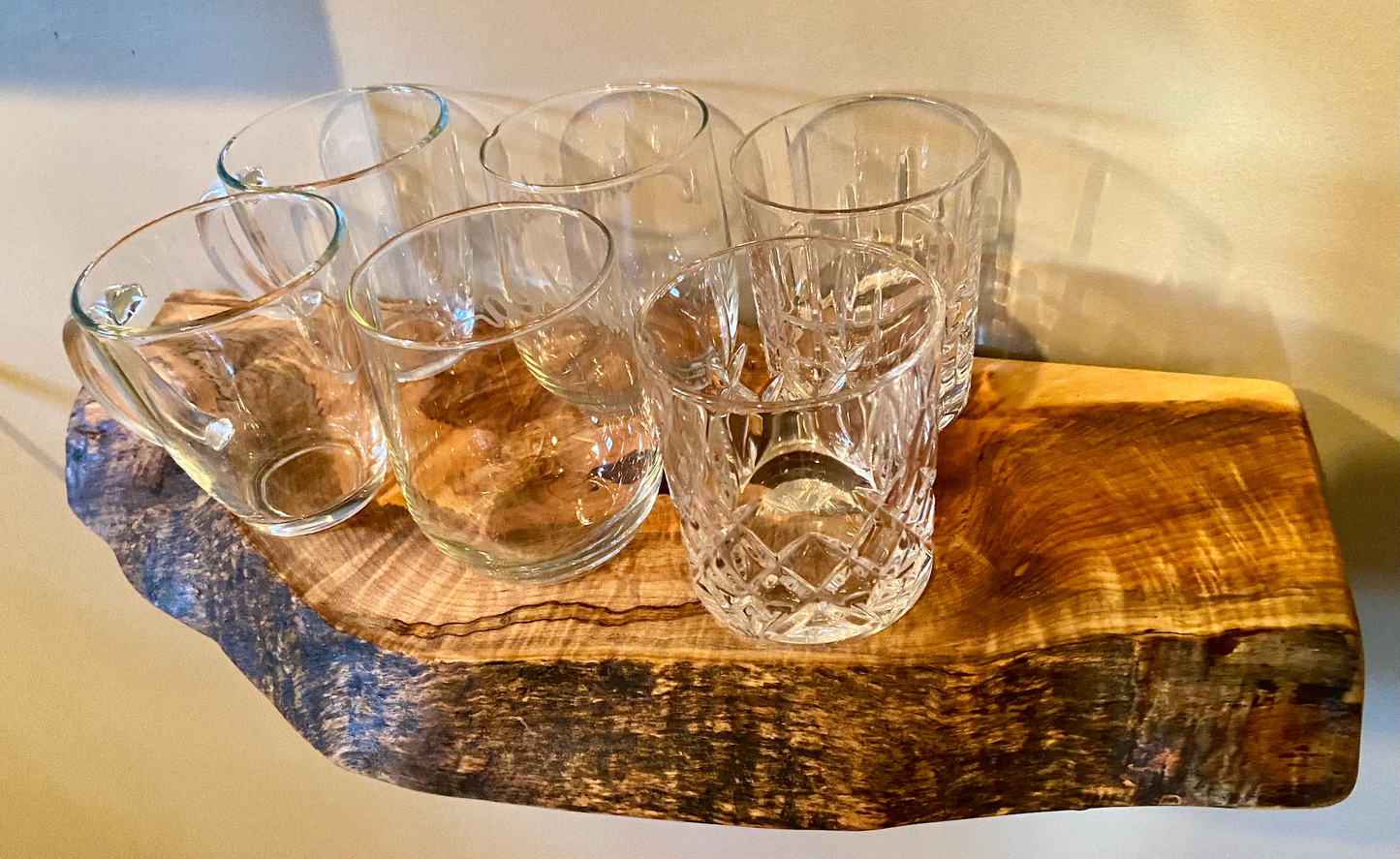 Handcrafted small live edge ambrosia maple floating shelf mounted on a wall, displaying glassware items. Close-up of the live edge detail on an ambrosia maple floating shelf, highlighting the natural wood grain and unique wormy patterns. Side view of a small ambrosia maple floating shelf with concealed brackets, showcasing its sleek, minimalist design.