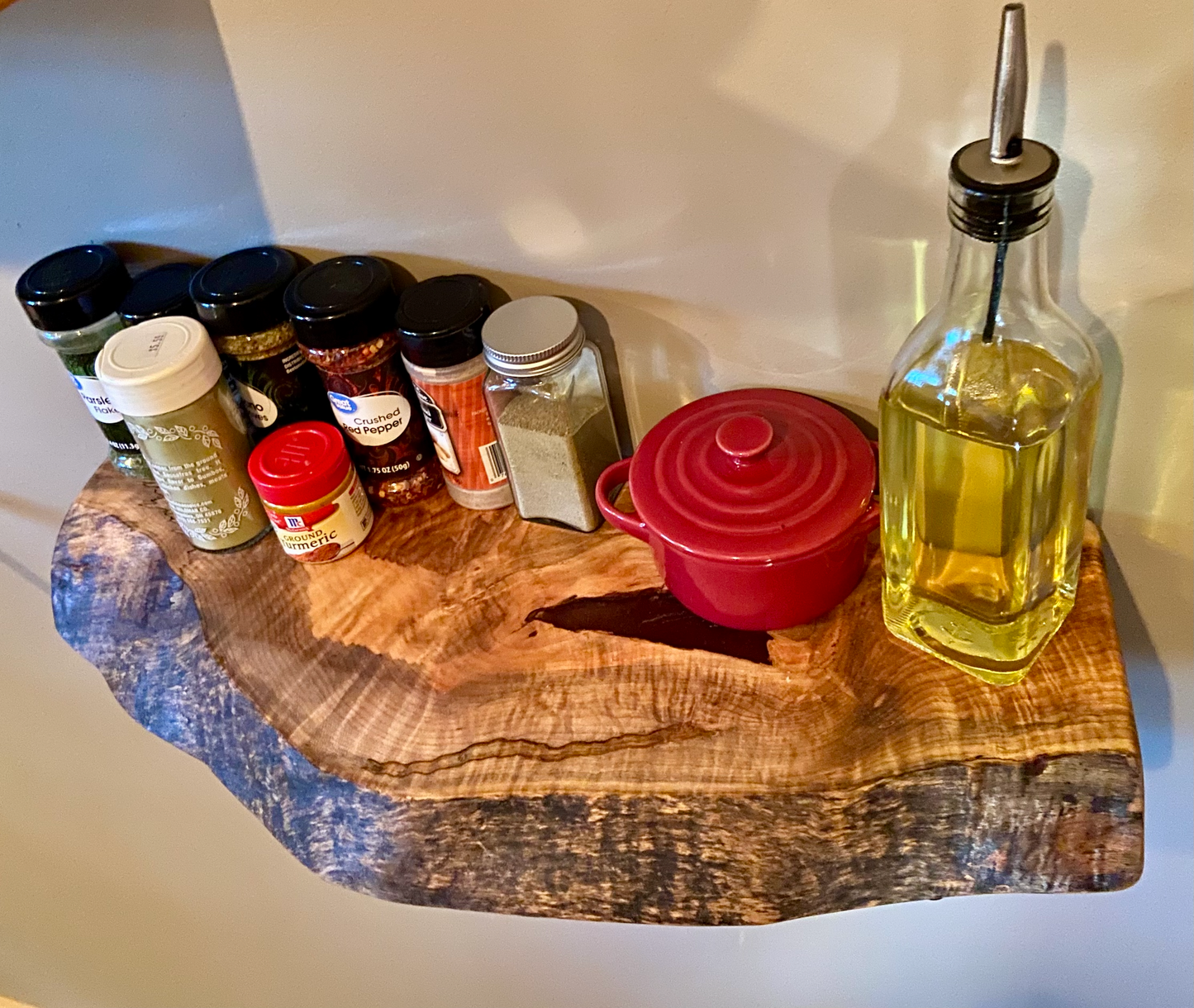 Handcrafted small live edge ambrosia maple floating shelf mounted on a wall, displaying household items. Close-up of the live edge detail on an ambrosia maple floating shelf, highlighting the natural wood grain and unique wormy patterns. Side view of a small ambrosia maple floating shelf with concealed brackets, showcasing its sleek, minimalist design.