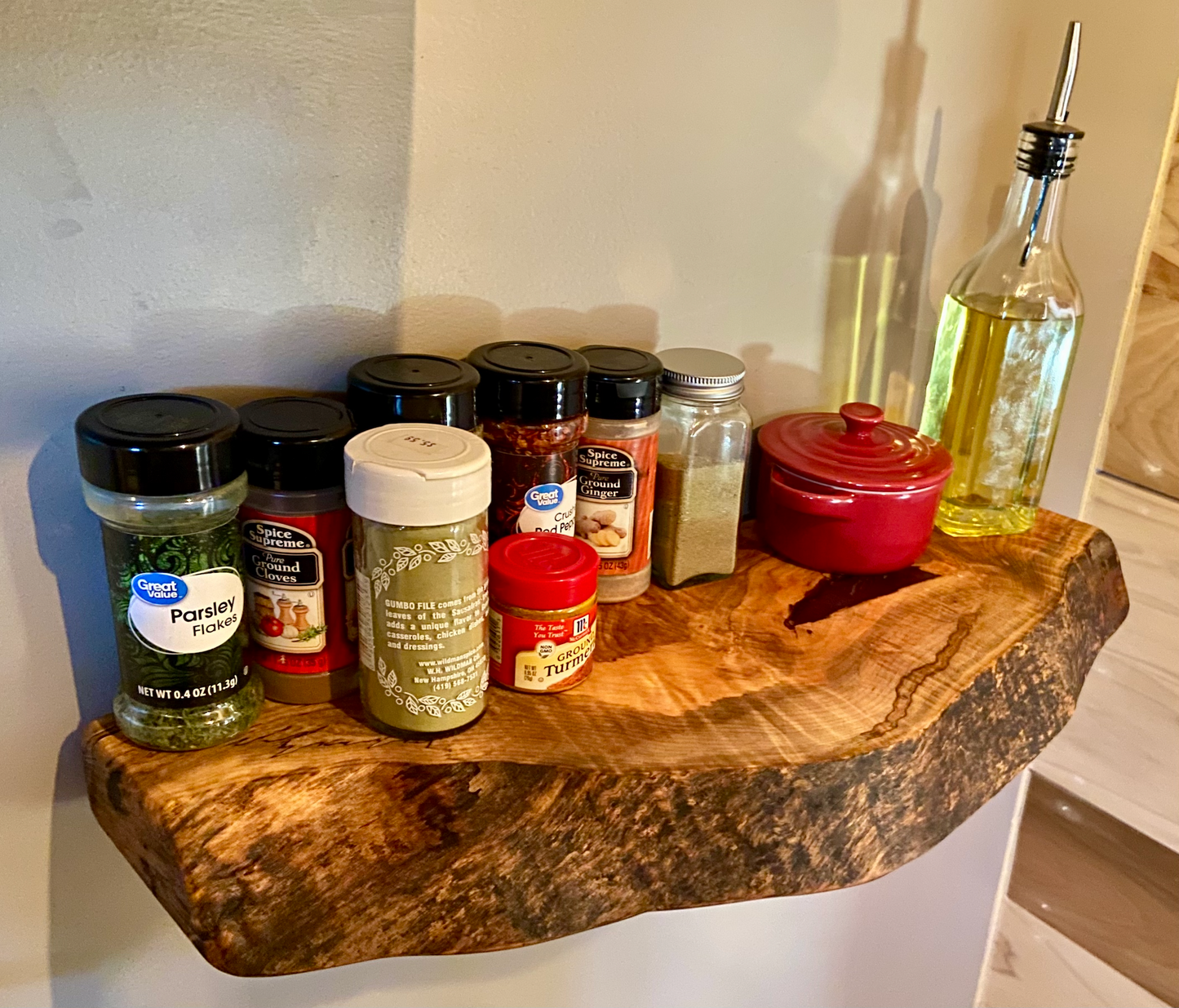 Handcrafted small live edge ambrosia maple floating shelf mounted on a wall, displaying household items. Close-up of the live edge detail on an ambrosia maple floating shelf, highlighting the natural wood grain and unique wormy patterns. Side view of a small ambrosia maple floating shelf with concealed brackets, showcasing its sleek, minimalist design.