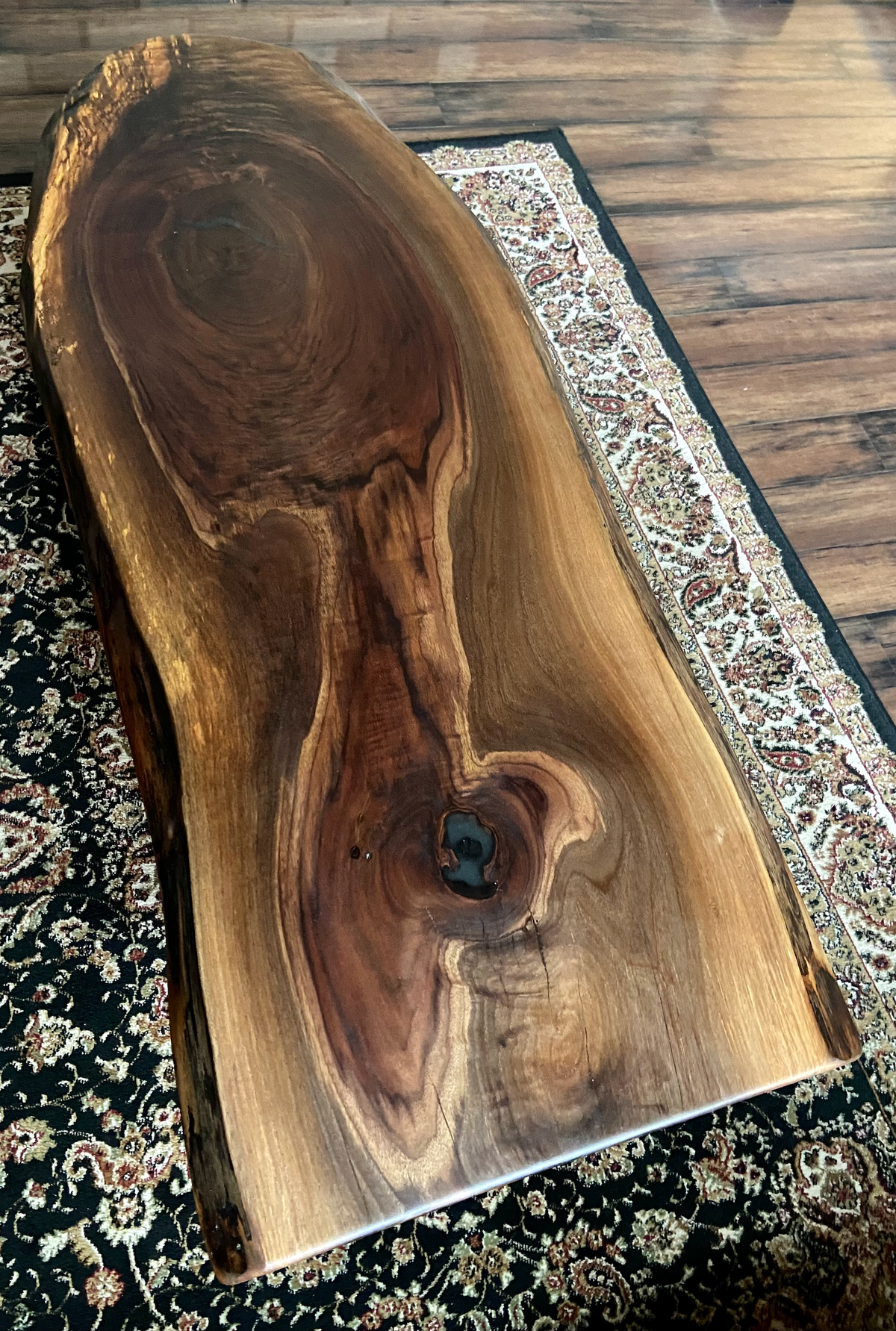 Ultra unique oval rustic natural live edge black walnut coffee table offers natural walnut wood with gorgeous grain patterns, complete with a large knot, a smaller knot, radial grain dancing around the entire table, completed with curl and a long oval shape.