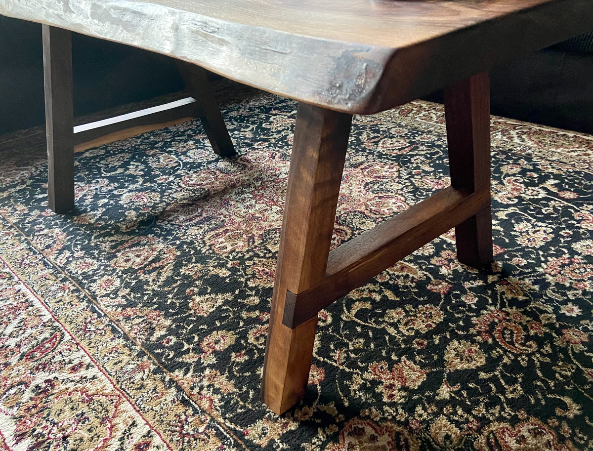 Ultra unique oval rustic natural live edge black walnut coffee table offers natural walnut wood with gorgeous grain patterns, complete with a large knot, a smaller knot, radial grain dancing around the entire table, completed with curl and a long oval shape.