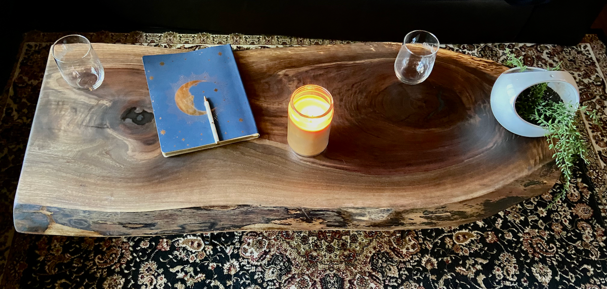 Live edge black walnut wood coffee table with gorgeous grain patterns, complete with a large knot, a smaller knot, and radial grain dancing around the entire table.