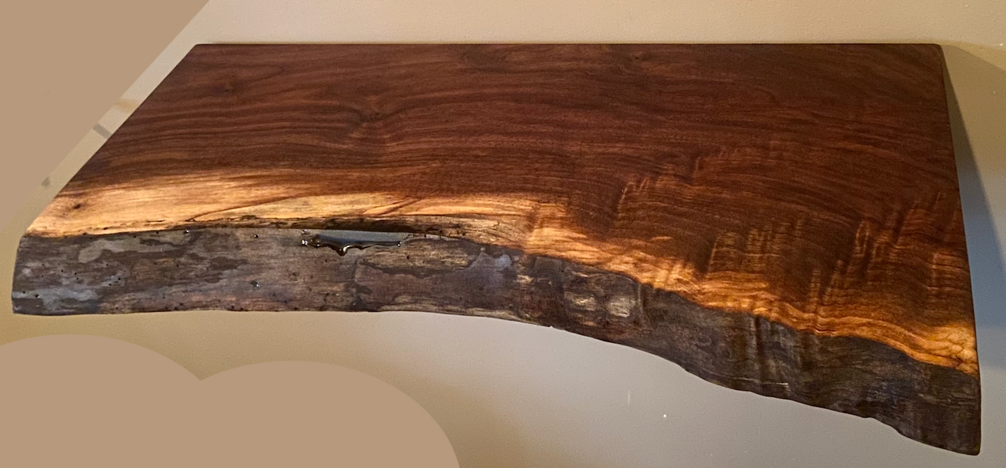 Wooden live edge floating shelf with a natural edge on a light background