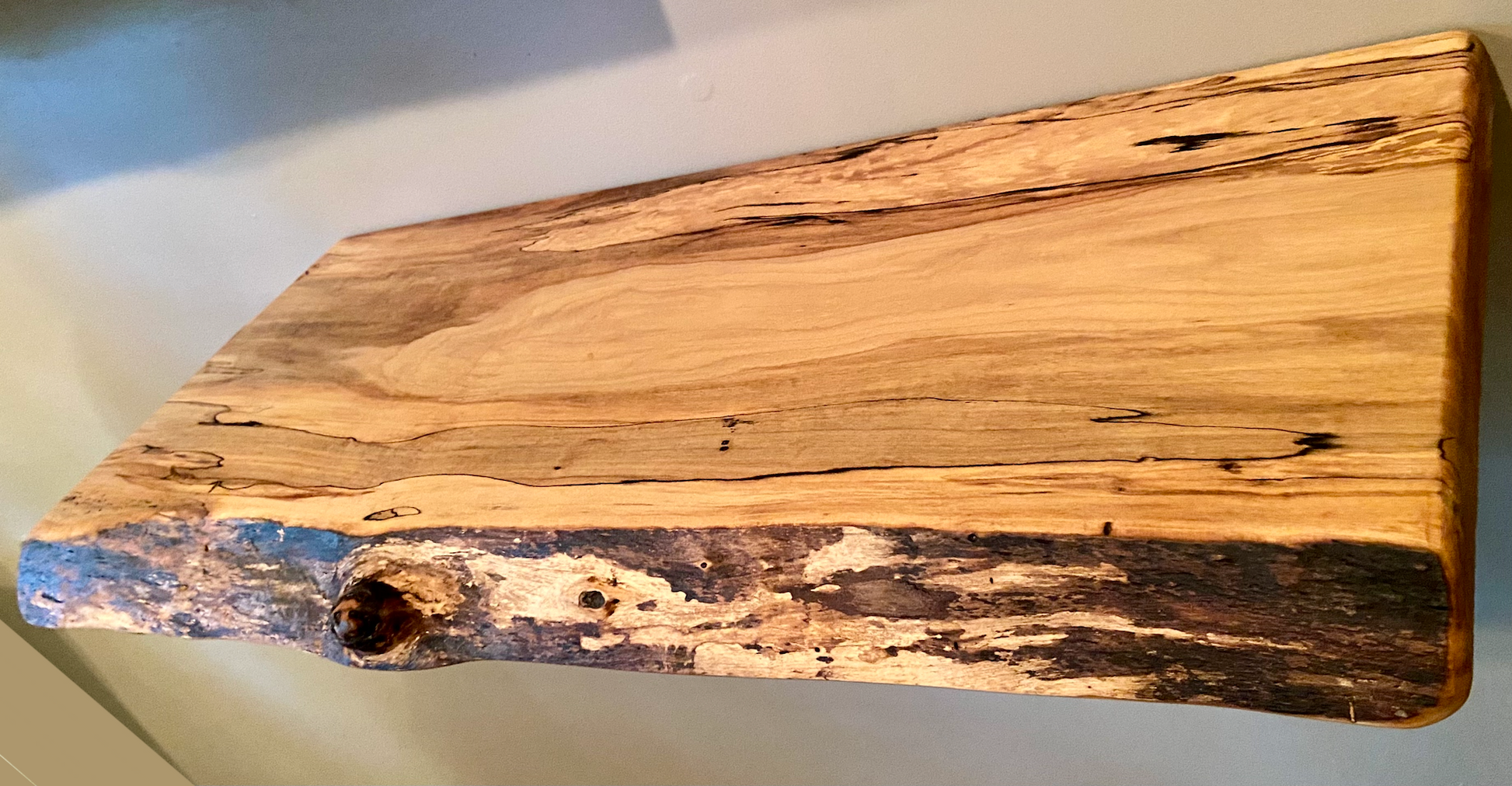 Spalted maple floating shelf with live edge, wall-mounted and handcrafted from natural wood.