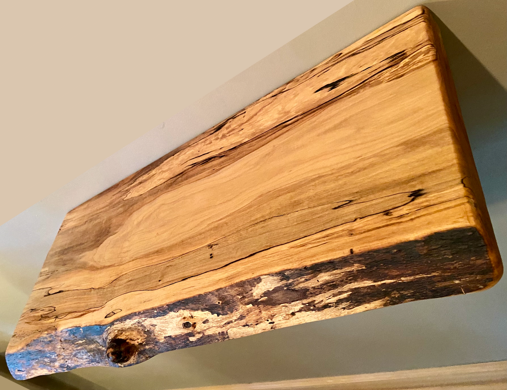 Spalted maple floating shelf with live edge, wall-mounted and handcrafted from natural wood.