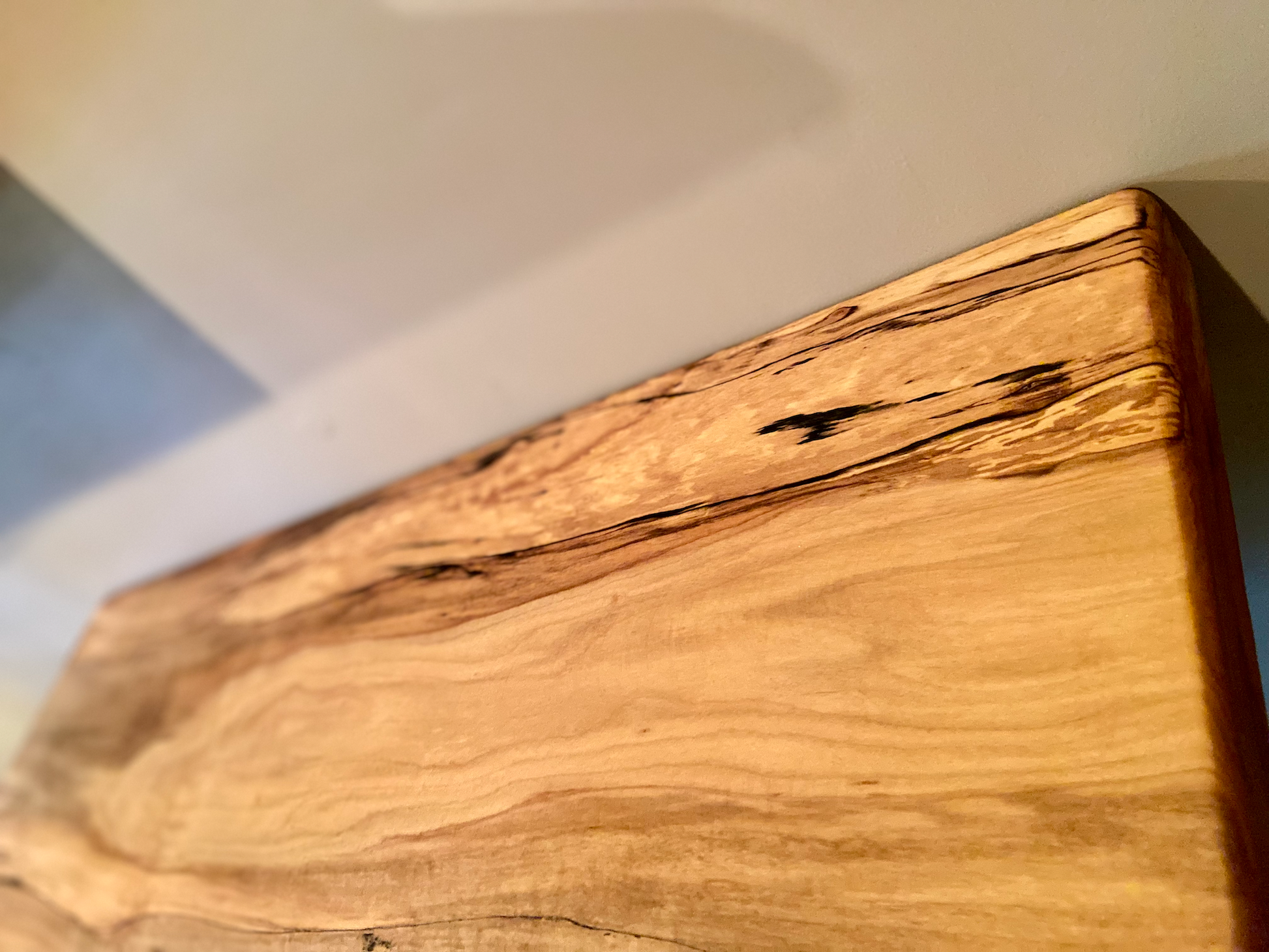 Spalted maple floating shelf with live edge, wall-mounted and handcrafted from natural wood.