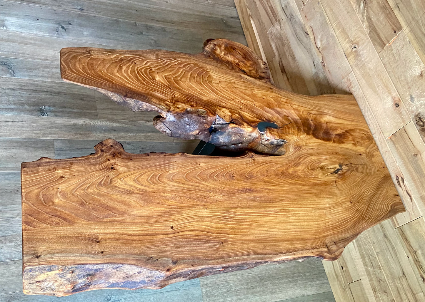 Wooden coffee table with a natural, wavy grain pattern on a wooden floor.