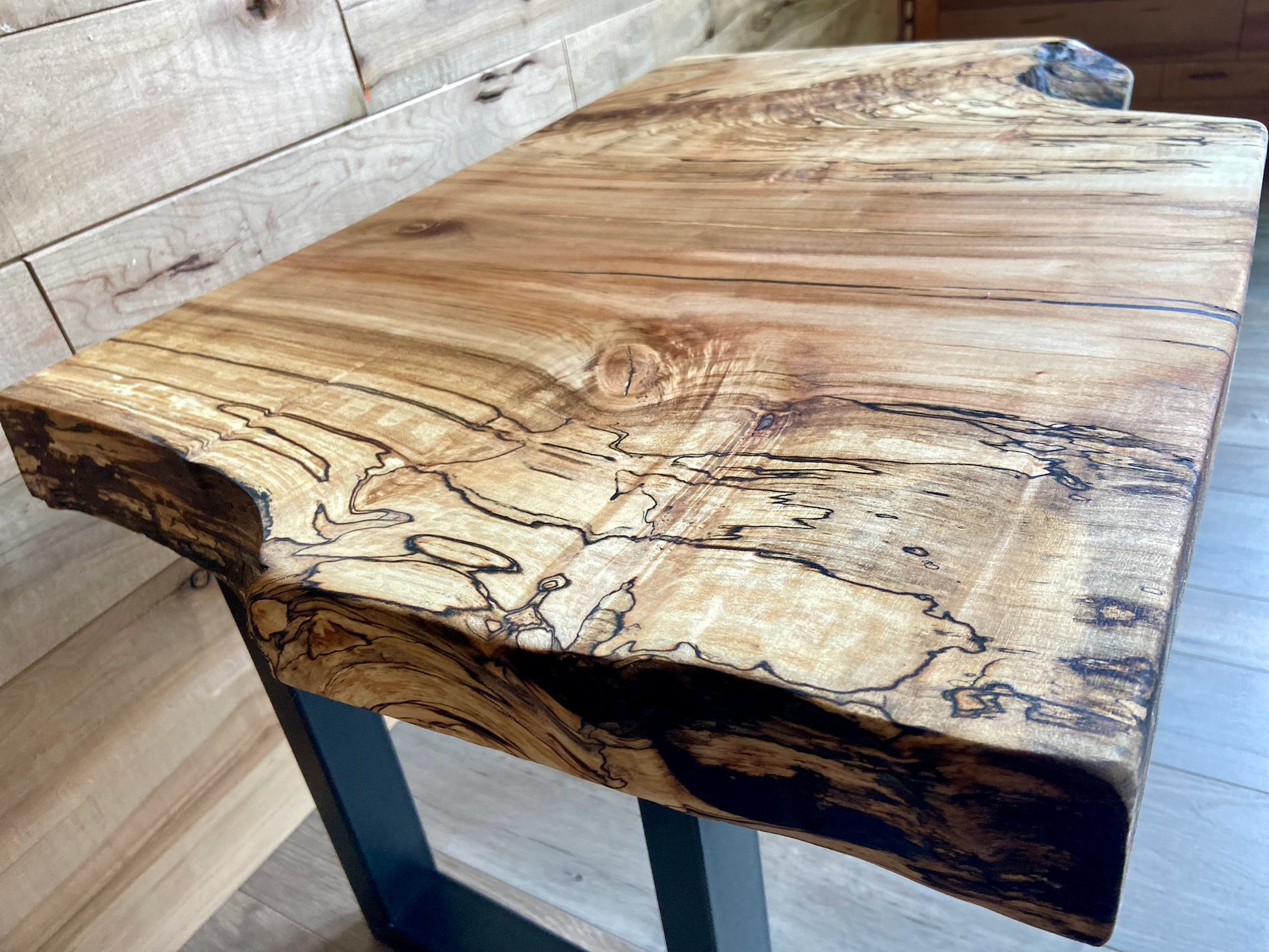 Wooden table with a natural, rustic finish against a wooden wall.