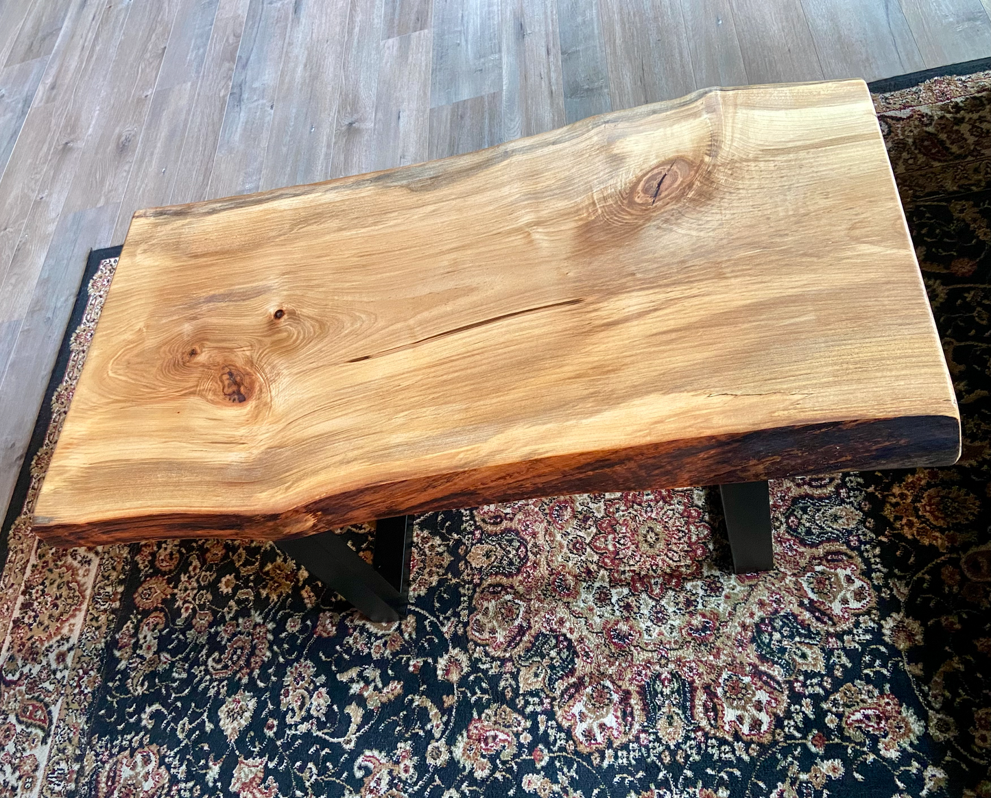 Live edge spalted ambrosia maple wood slab coffee table with a natural finish on a patterned rug