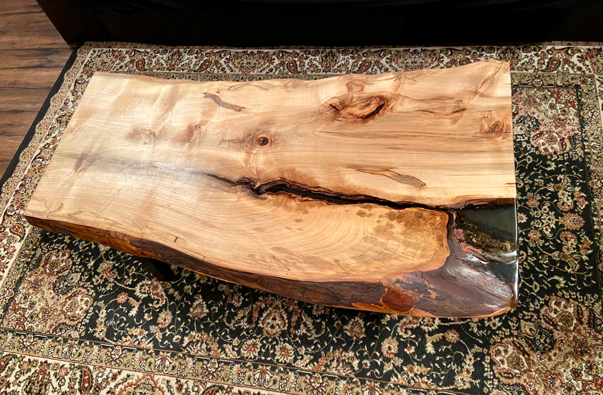 Live edge spalted ambrosia maple wood slab coffee table with a natural finish on a patterned rug