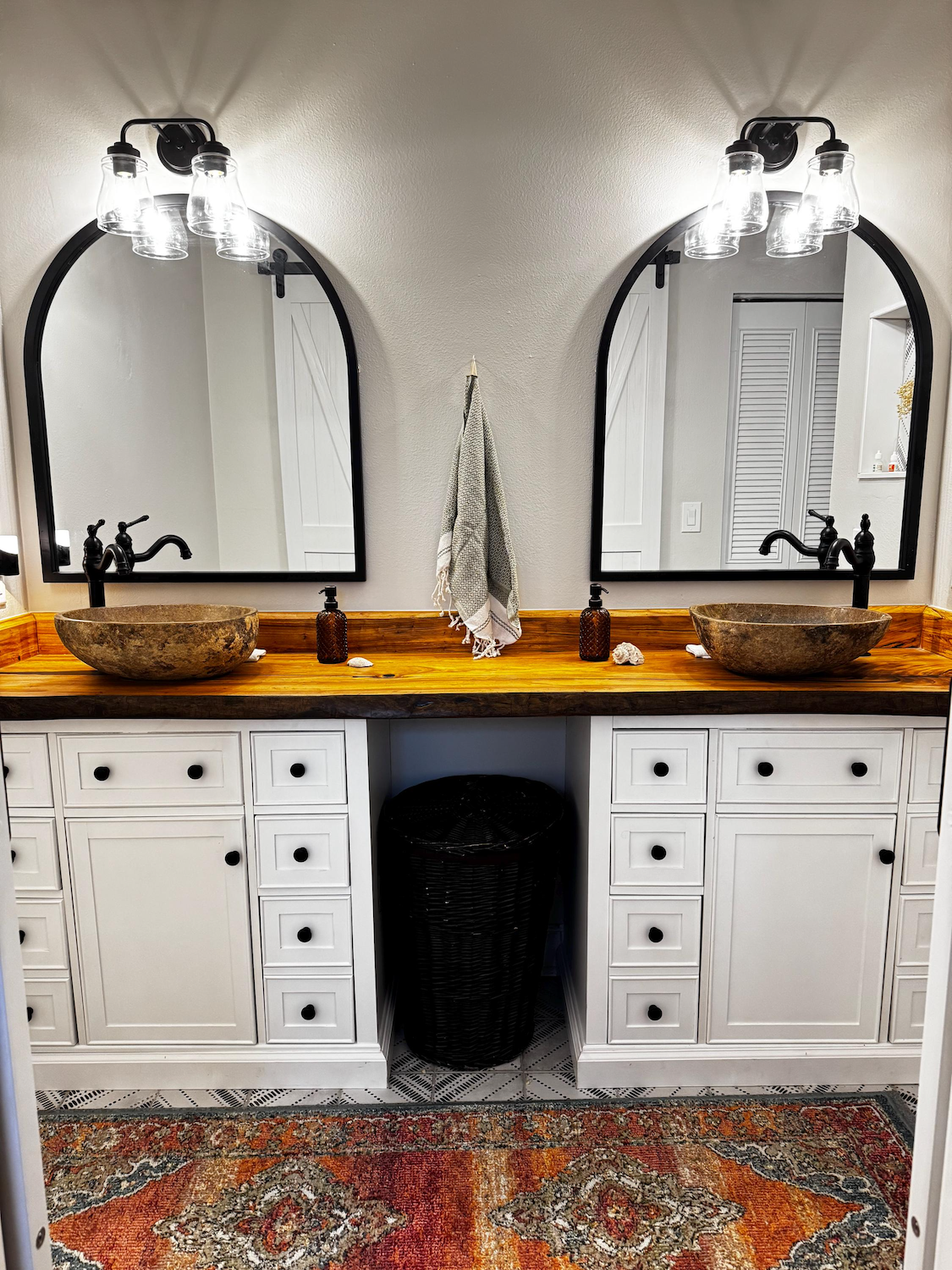 Bathroom with live edge chestnut double vanity, mirrors, and wooden countertop.