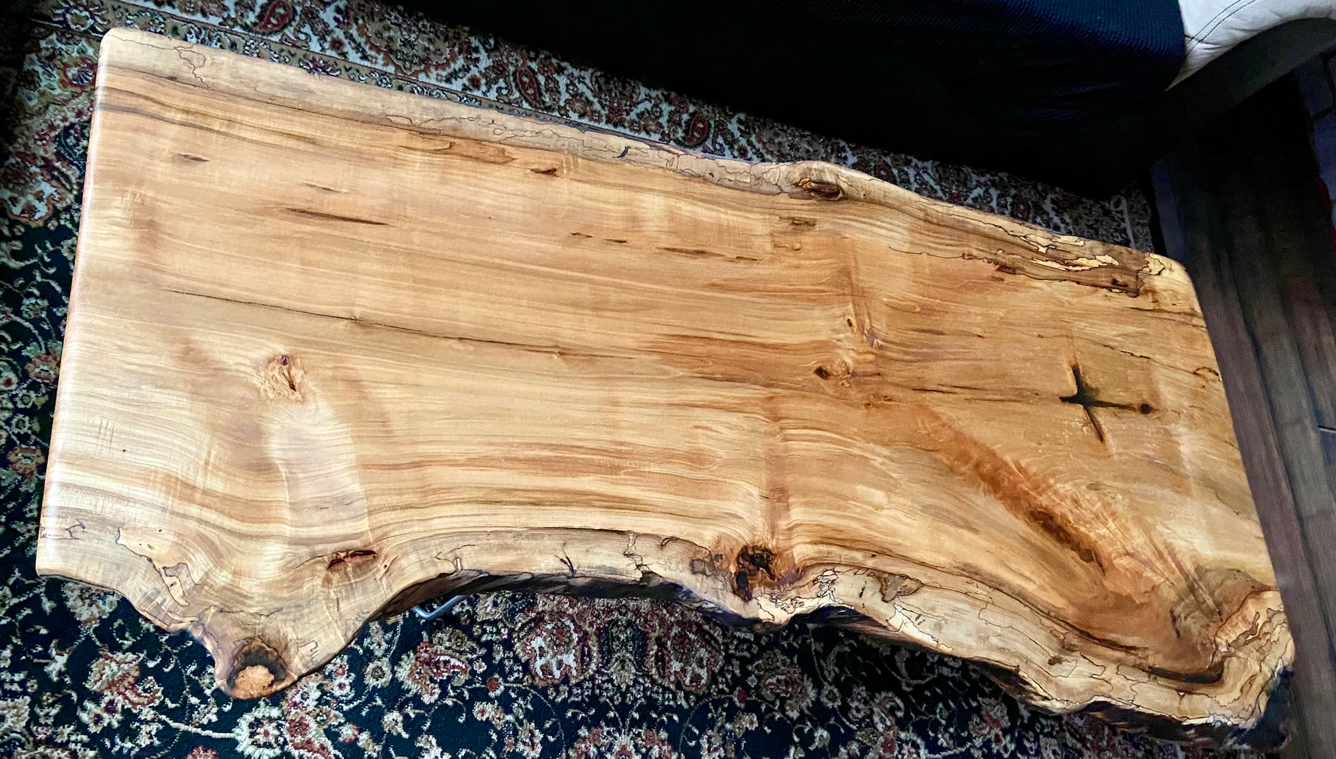 Live edge spalted ambrosia maple wood slab coffee table with natural edge on a patterned rug