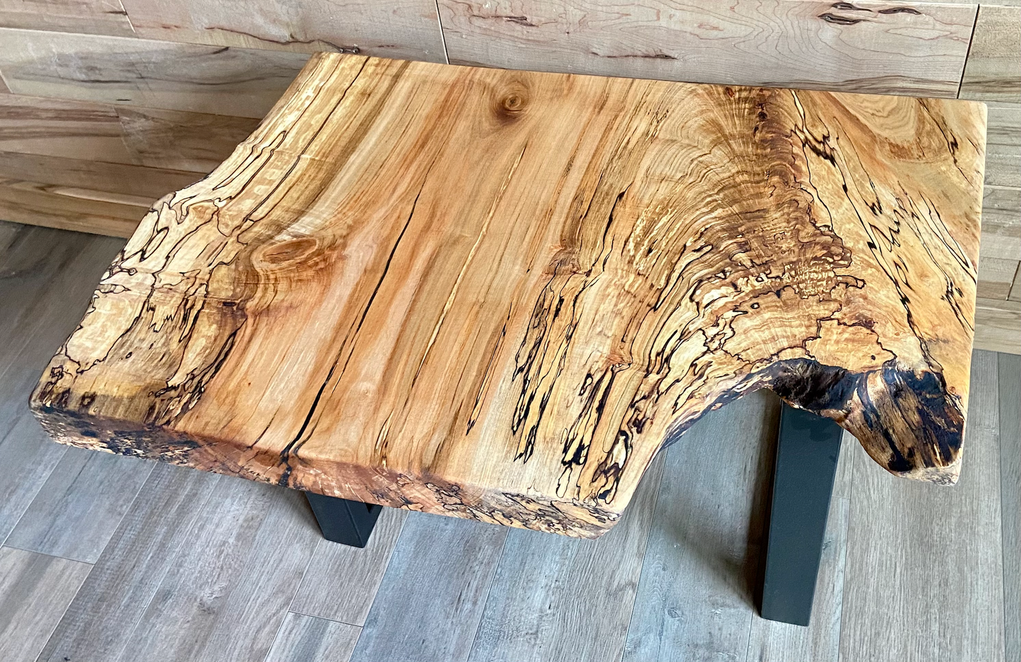 Wooden maple live edge end table with a natural finish. 