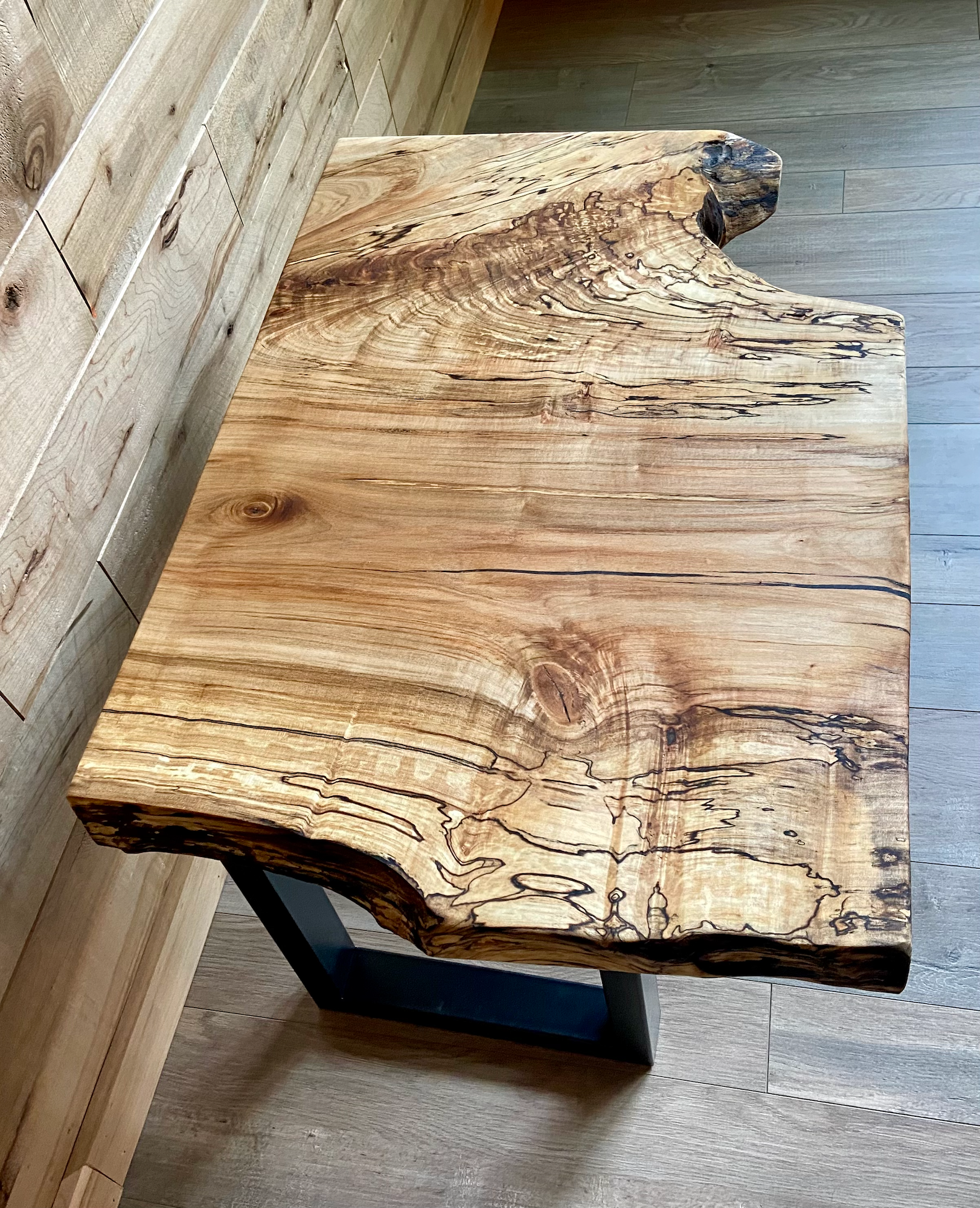 Wooden table with a natural, rustic finish on a wooden floor.