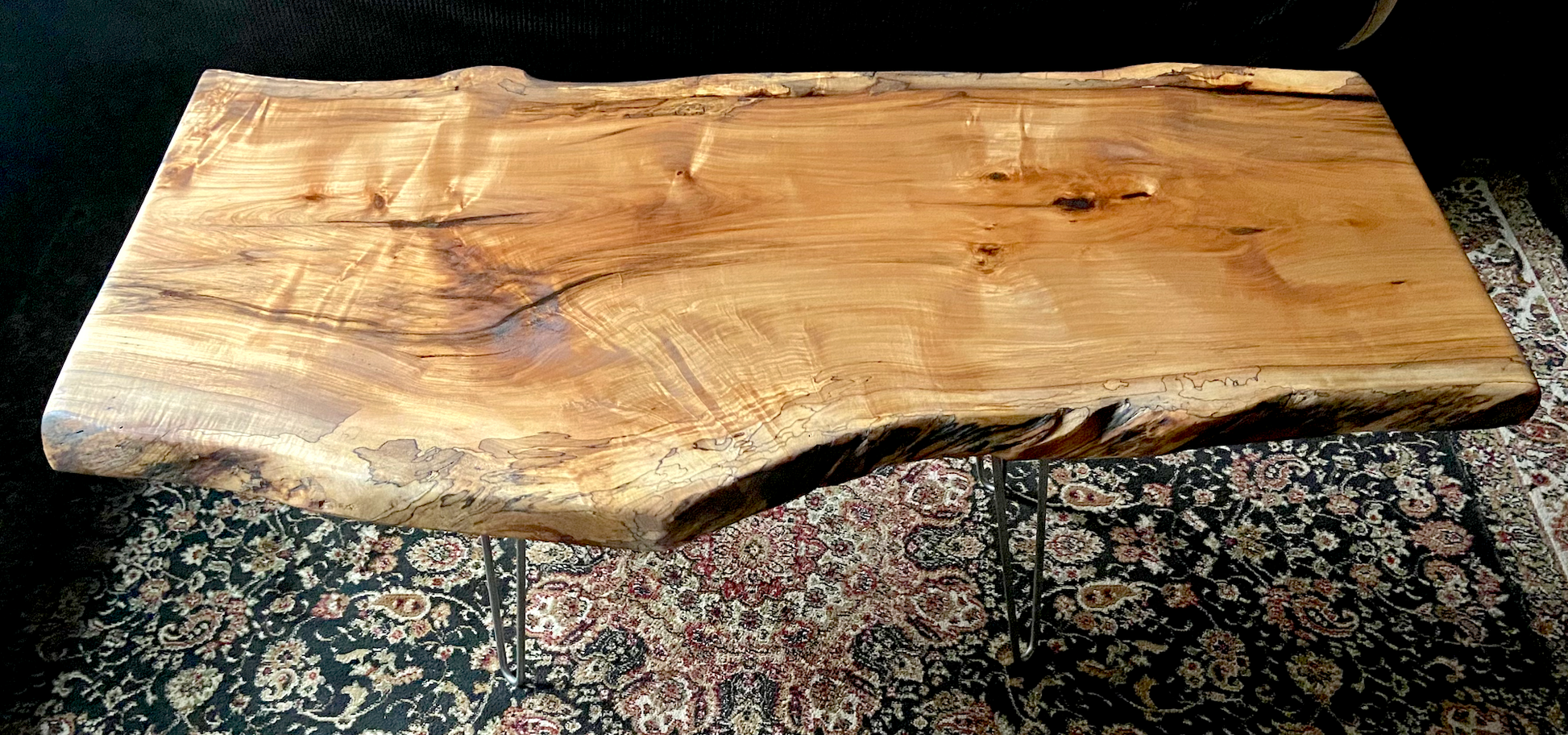 Live edge spalted ambrosia maple wood slab coffee table made from a single piece of wood on a patterned rug
