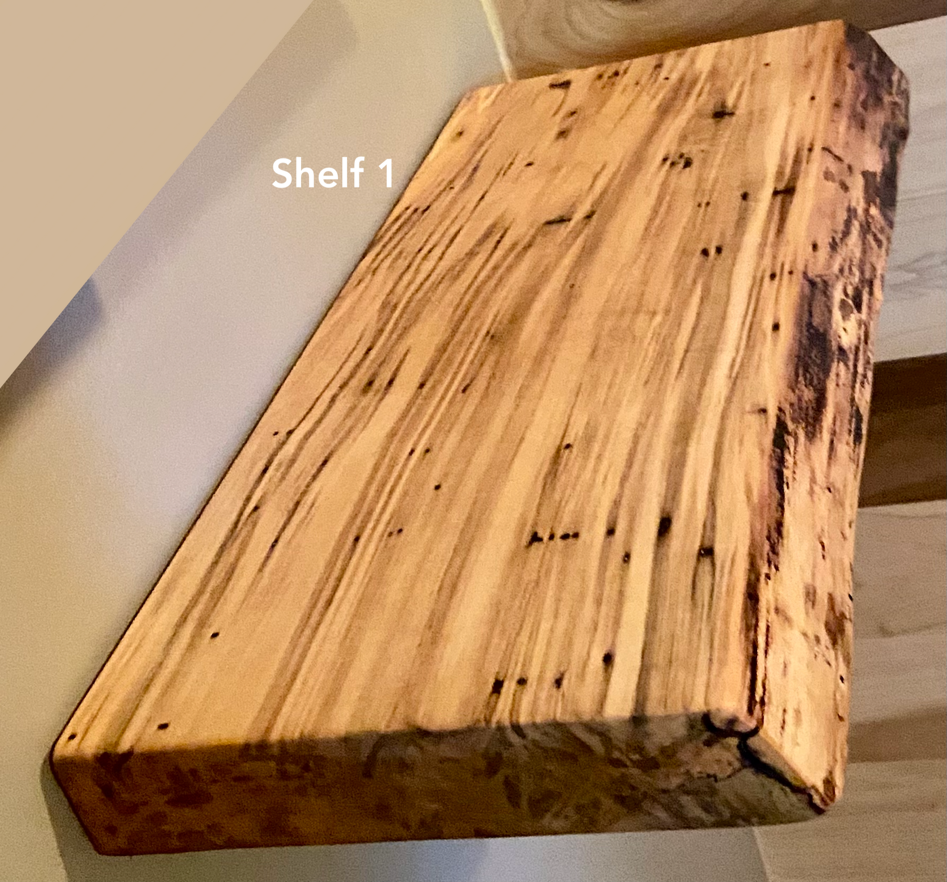 Live edge ambrosia maple floating shelf with live edge and natural grain pattern mounted on wall.
