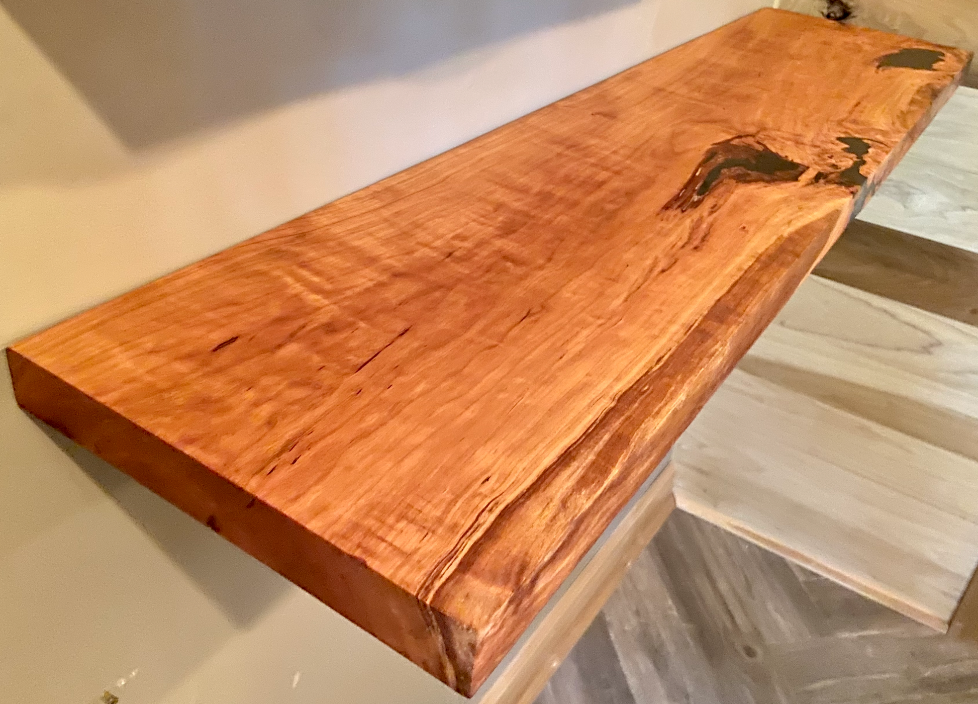 Front view of a handcrafted cherry floating shelf mounted on a wall. Close-up of the solid cherry wood grain, highlighting the shelf’s smooth finish. Side angle showcasing the shelf’s thickness and sturdy wall brackets.