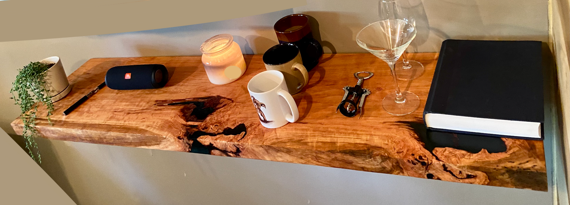 Front view of a handcrafted cherry floating shelf mounted on a wall, displaying decorative items. Close-up of the solid cherry wood grain, highlighting the shelf’s smooth finish. Side angle showcasing the shelf’s thickness and sturdy wall brackets.