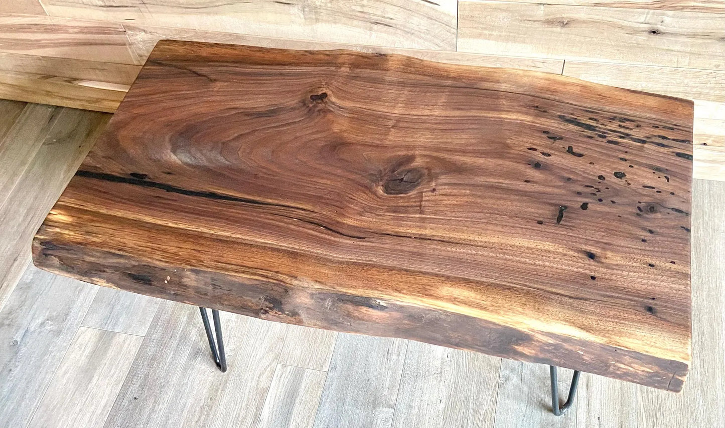 Live edge walnut wood slab coffee table with a rustic design on a wooden floor